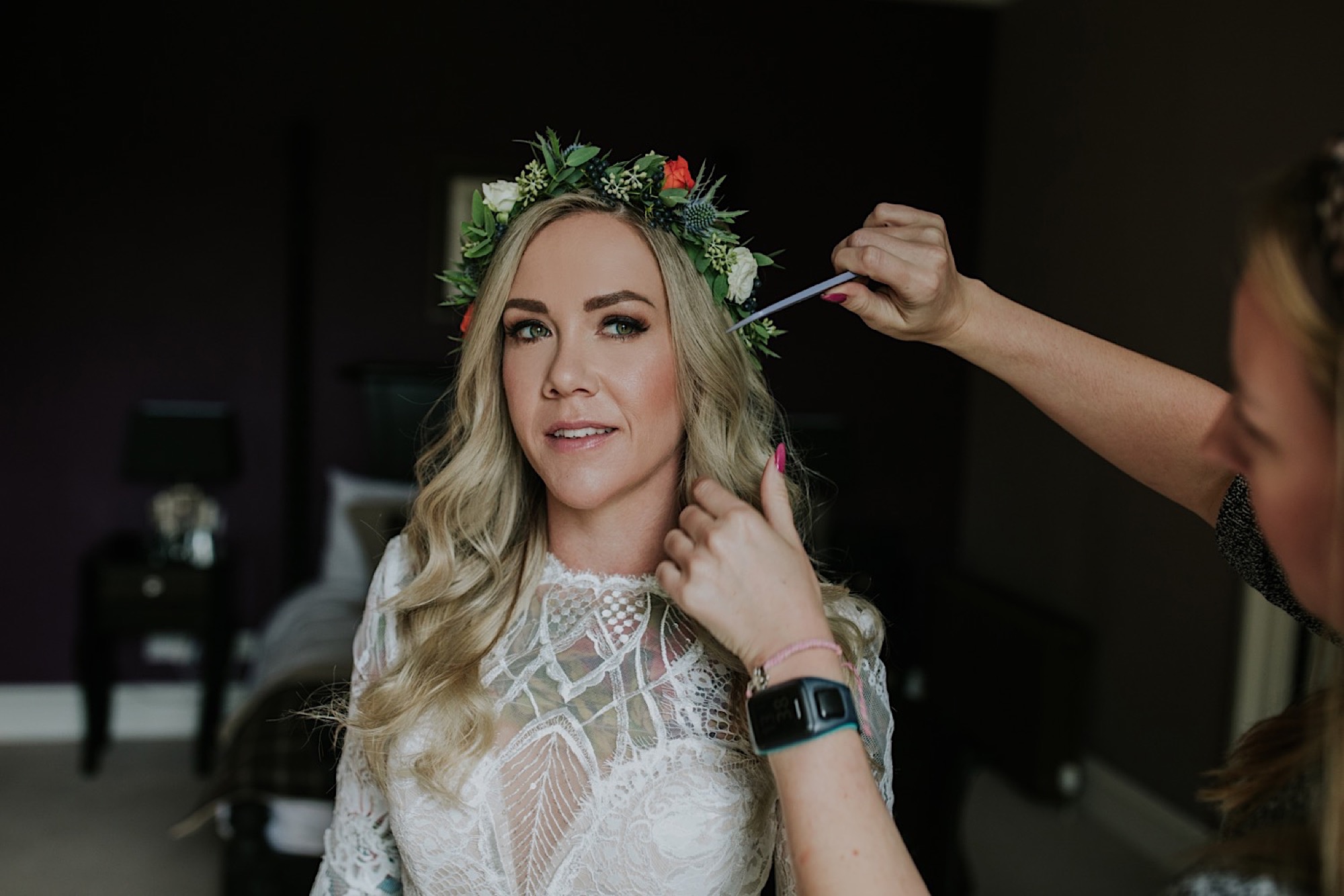 bride having her hair styled on her wedding day 