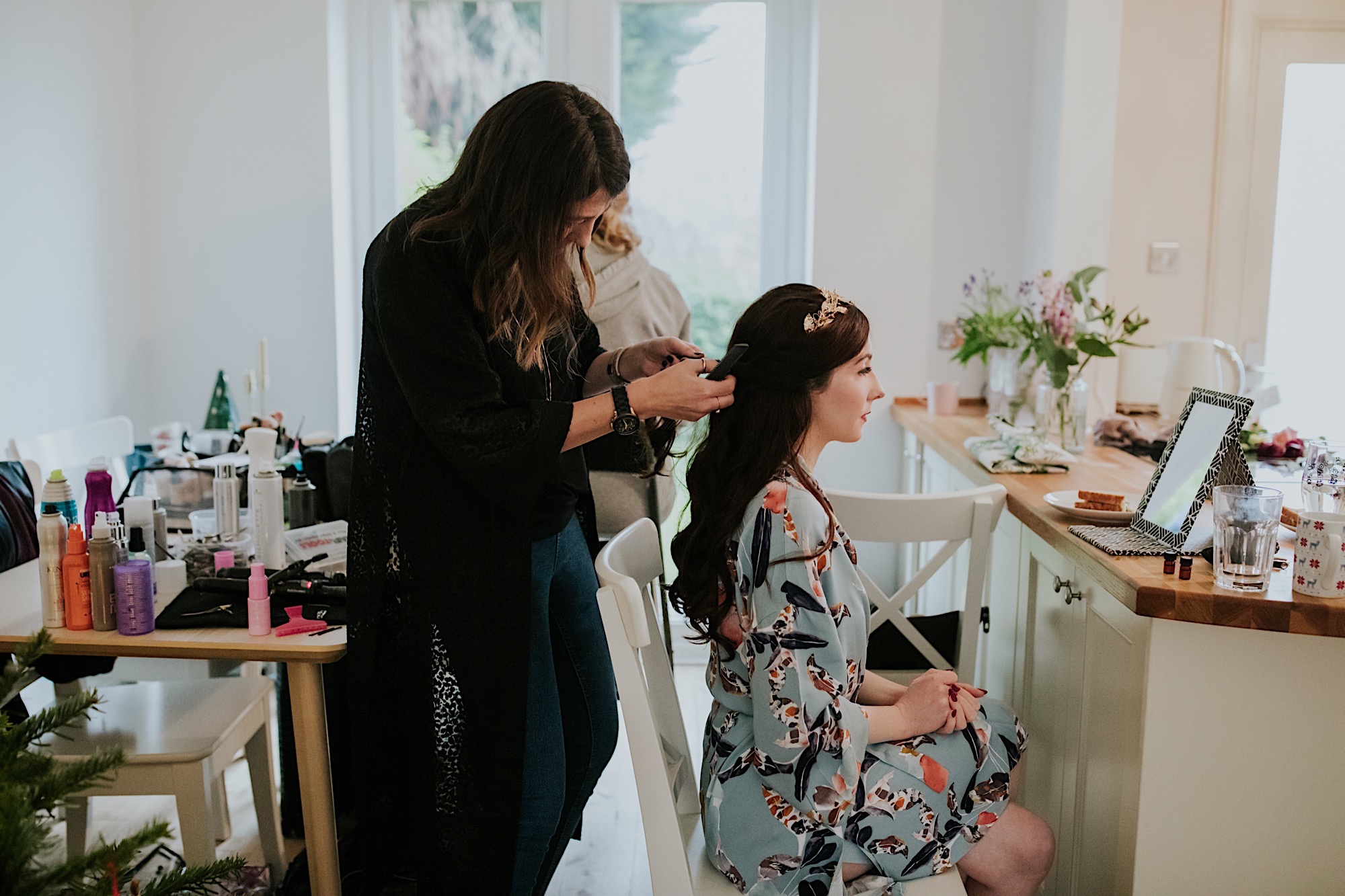 bride in her kitchen having her hair done wearing flower crown